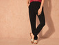 Pantalon noir à jambes larges avec des sandales blanches.