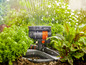 Un arroseur Gardena arrose des plantes dans le jardin.