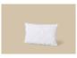 Oreiller blanc matelassé avec un motif ondulé sur fond beige.