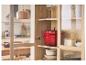 Casseroles rouges en fonte et autres ustensiles de cuisine dans une armoire en bois.
