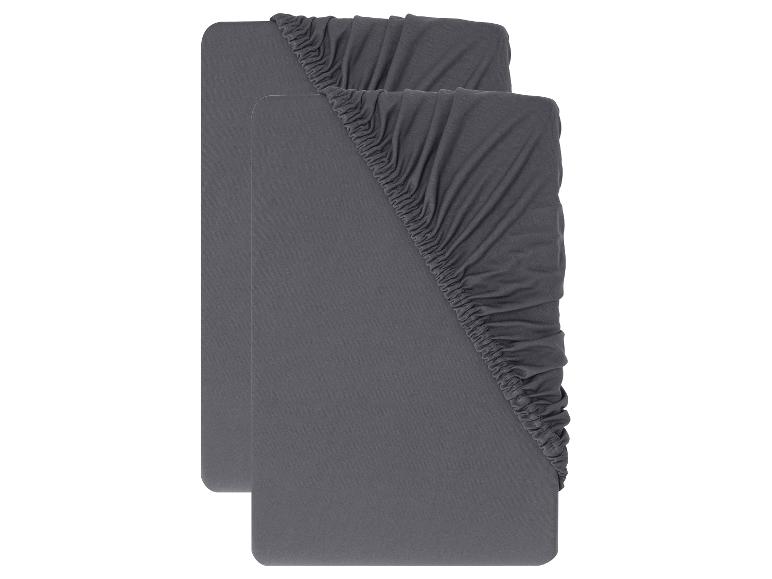 Deux draps-housses gris, pliés et disposés l'un derrière l'autre