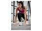Une femme en brassière de sport et leggings fait de l'exercice.