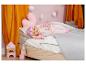 Poupée Baby Born en pyjama rose dormant dans un lit d'enfant avec des jouets.
