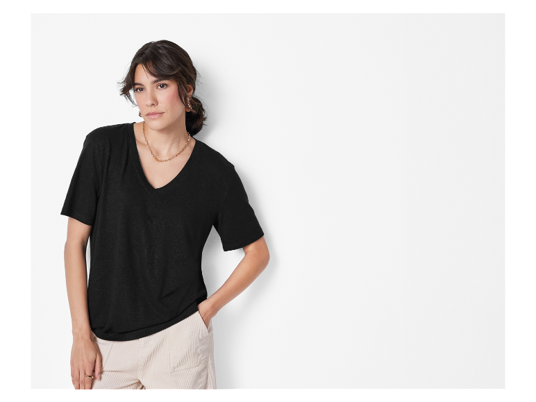 Modèle portant un t-shirt noir et un pantalon beige.