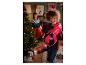 Un enfant avec des gants de boxe rouges et un sac de frappe rouge de Crivit devant un sapin de Noël.