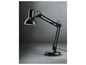 Une lampe de bureau noire ajustable sur un fond gris.