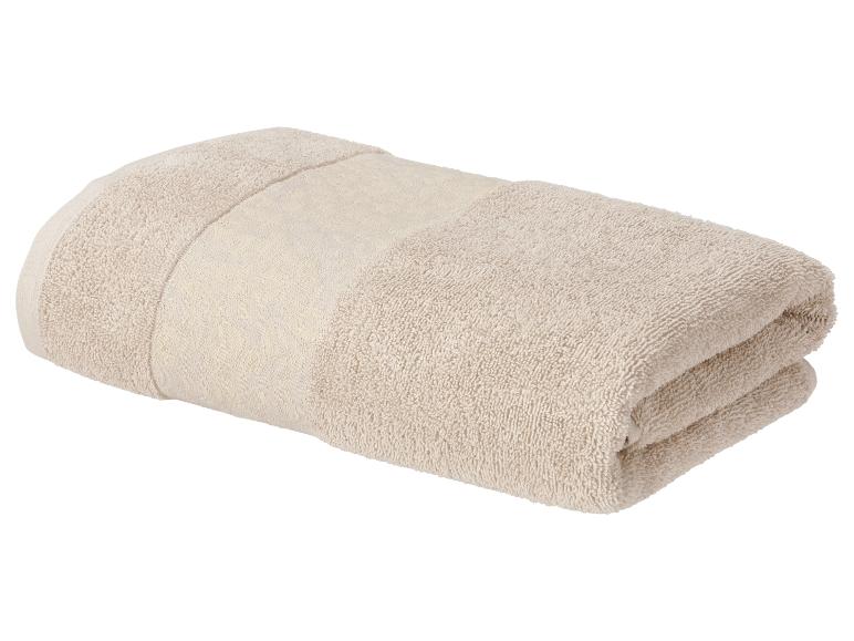 Serviette de bain beige pliée avec une bande décorative