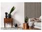 Salon moderne avec une commode en bois, une plante et un canapé gris clair.