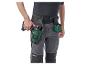 Homme en pantalon de travail et ceinture porte-outils avec perceuse sans fil et vis.