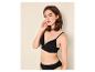 Femme en soutien-gorge et culotte noirs sans couture, posant sur fond clair.