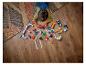 Un enfant joue avec des voitures de course LEGO Duplo et un avion sur un parquet.