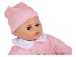 Une poupée bébé rose avec un bonnet rose.