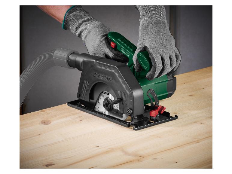 Scie circulaire à main avec aspirateur pour bois, utilisée par une personne gantée