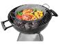 Poulet, légumes et champignons grillés dans un wok sur un barbecue.