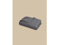 Couverture lestée gris foncé avec un motif subtil, pliée sur un fond beige.