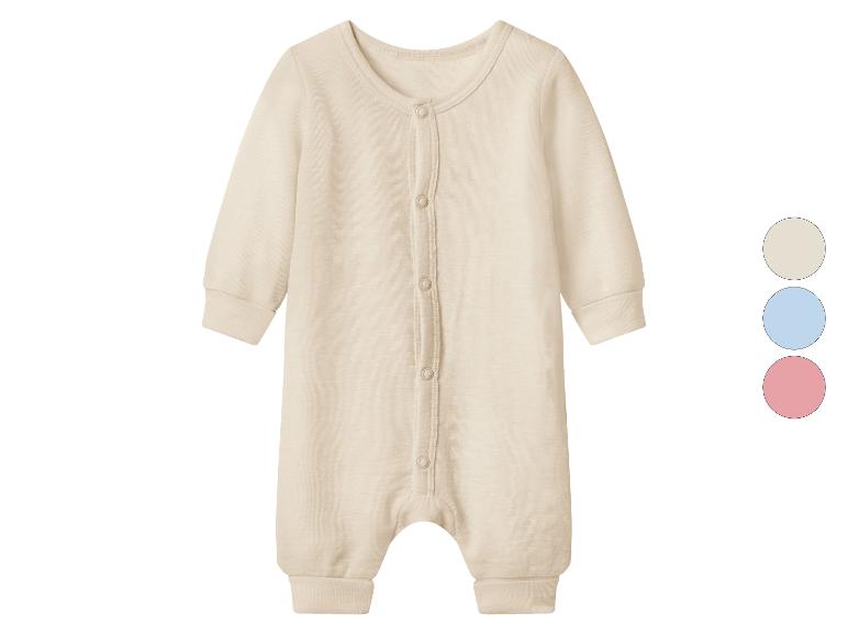 Grenouillère bébé beige clair avec boutons et échantillons de couleur beige, bleu et rose.