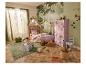 Une chambre d'enfant avec un lit cabane, du papier peint forêt et des cubes de rangement roses.