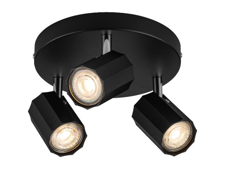 Plafonnier noir à trois lumières orientables.