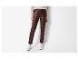 Pantalon marron en simili cuir avec baskets blanches.