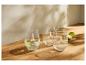 Trois verres en verre, un avec de l'eau, du citron vert et de la menthe, sur une table en bois.
