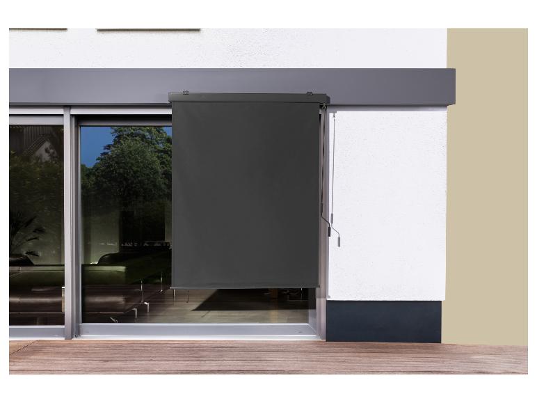 Store extérieur sur porte-fenêtre, partiellement baissé, avec terrasse en bois.