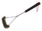 Une brosse de nettoyage pour barbecue noire avec des poils métalliques.