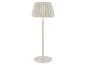 Lampadaire blanc avec un abat-jour plissé, émettant une lueur chaude.