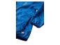 Veste bleue avec imprimé de briques de jouet et une étiquette rouge.