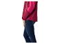 Femme portant une veste bicolore rose et bordeaux avec un jean bleu foncé.
