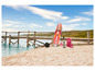 Un paddleboard Mistral rose avec accessoires sur une plage.