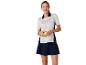 Polo et jupe de tennis ; une femme tient une balle de tennis.