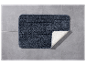 Un tapis de bain gris foncé sur des carreaux gris.