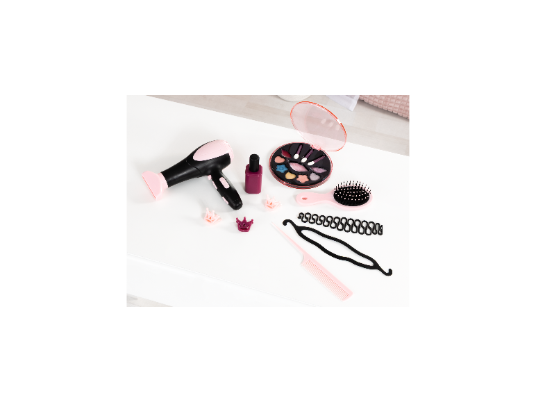 Sèche-cheveux jouet, palette de maquillage, brosse à cheveux et accessoires de coiffure sur fond blanc.