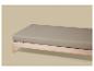 Matelas gris sur un cadre de lit en bois clair.
