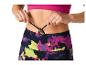 Femme ajustant le cordon d'un legging de sport imprimé.
