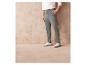 Un homme portant un pantalon cargo gris et des baskets blanches.