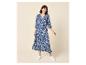 Femme en robe longue bleue et blanche à motifs avec manches 3/4 et baskets blanches.