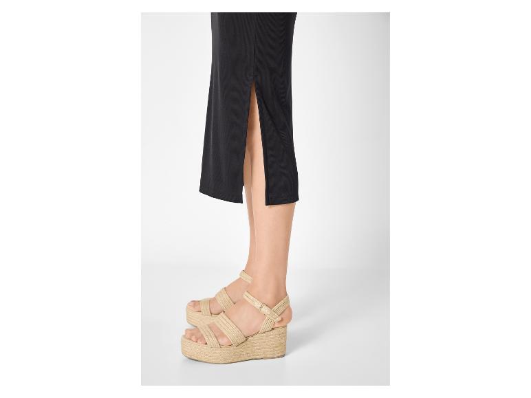 Femme en jupe noire et sandales compensées en espadrille