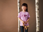 Une fille porte un t-shirt violet 'Nature Friends' avec un lapin et un écureuil.