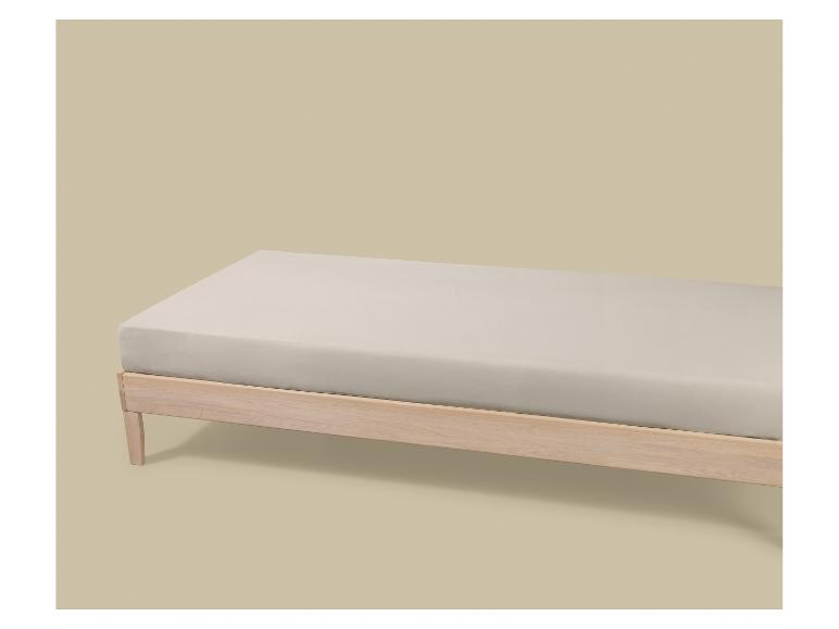 Lit simple en bois clair avec matelas et drap-housse beige.