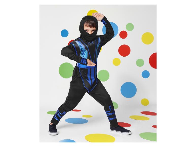 Un enfant dans un costume de ninja avec des détails bleus, posant devant un fond avec des cercles colorés.
