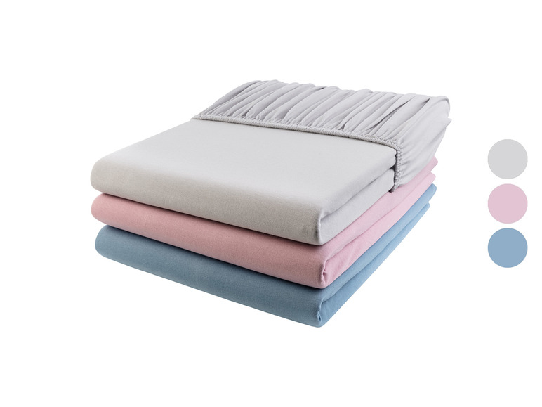 Une pile de draps en gris, rose et bleu.