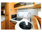 Cuisine d'un camping-car avec un évier, une plaque de cuisson et un robinet.