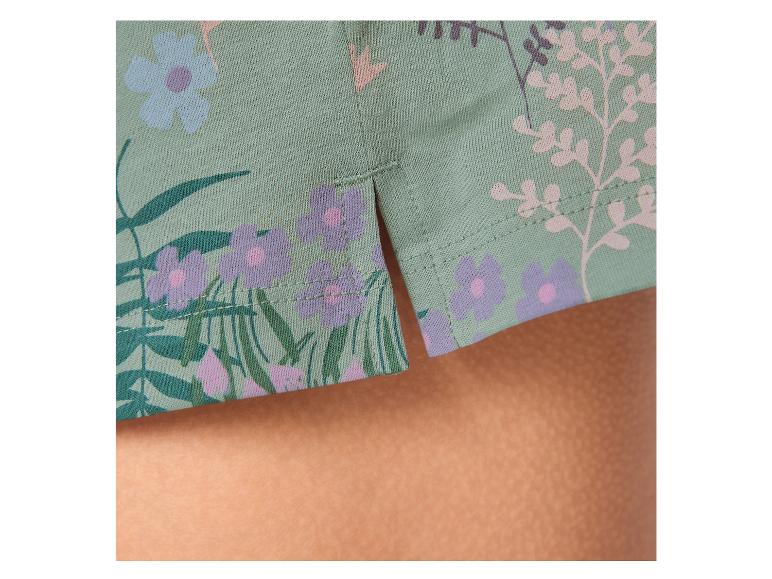 Détail d'un vêtement vert menthe avec imprimé floral et fentes latérales.