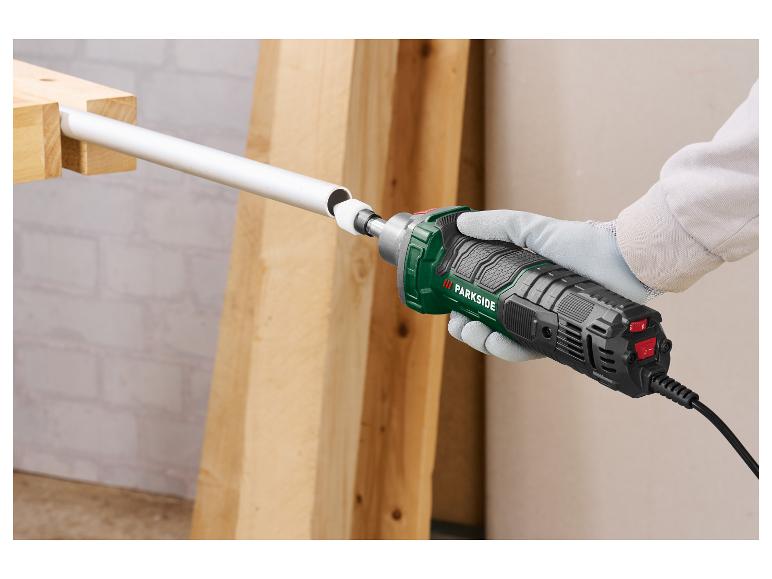 Une personne utilise une ponceuse Parkside pour poncer un tuyau blanc.