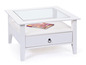 Table basse blanche avec plateau en verre et tiroir.