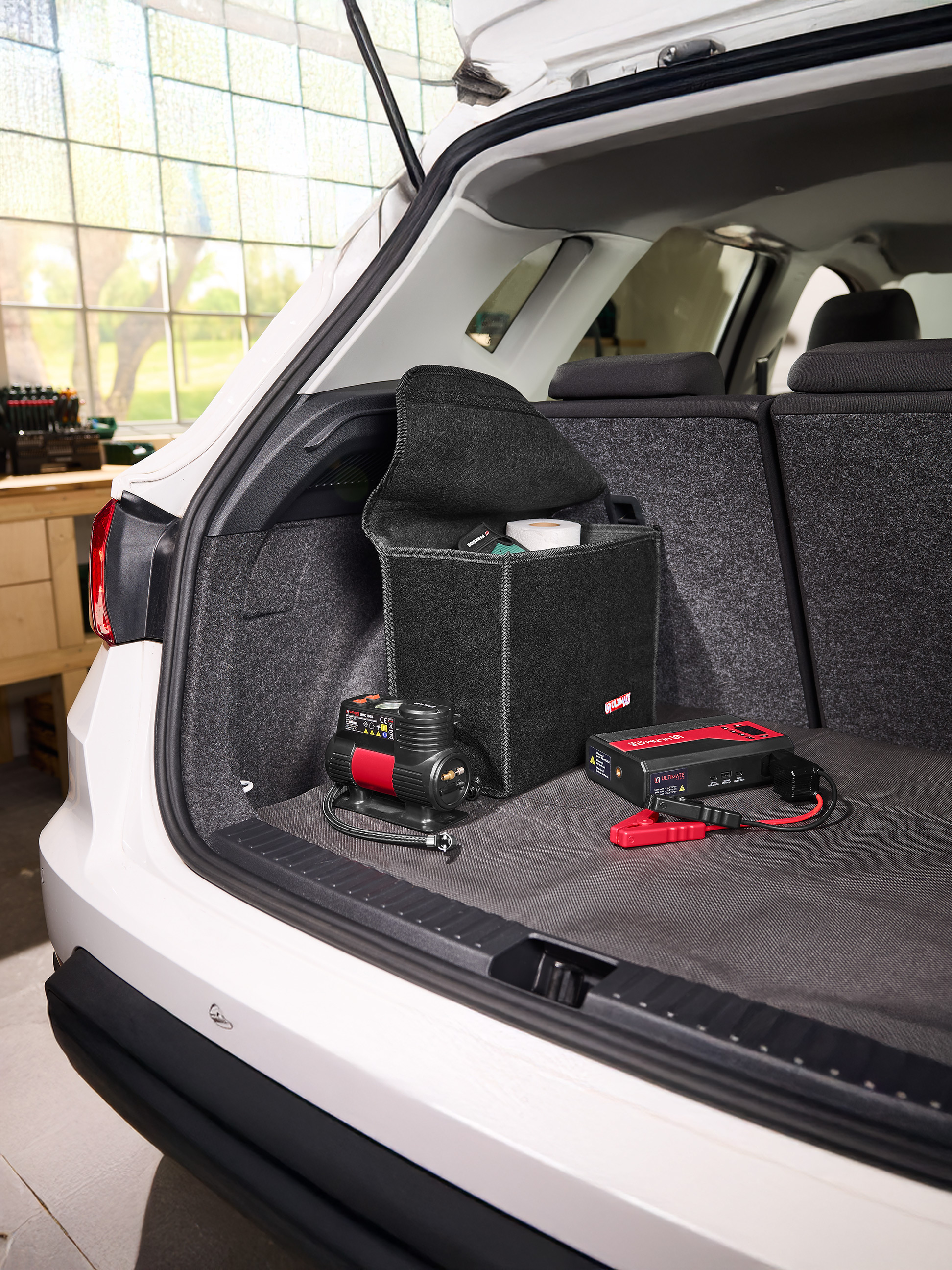 Coffre de voiture avec compresseur d'air, démarreur de batterie et organisateur en feutre.