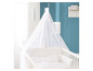 Un lit bébé blanc avec un ciel de lit et des draps étoilés.