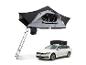 Tente de toit grise et noire avec échelle, installée au-dessus d'une voiture break blanche.