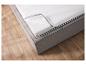 Un matelas en mousse gris avec un sommier sur un sol en bois.
